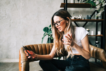 Emotional angry young woman having video call, screaming and gesturing.