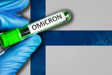 Finland outbreak of omicron variant. Hand holds a test tube with covid-19 virus omicron in front of...