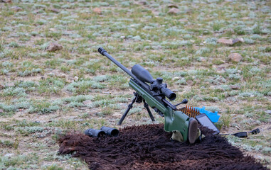 High-precision hunting rifle with an optical sight, cartridges and binoculars on the sighting.