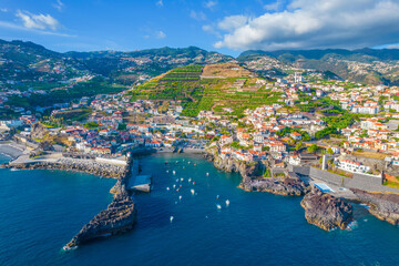 Aerial drone view of Camara de Lobos village panorama near to Funchal, Madeira. Small fisherman village with many small boats in a bay - obrazy, fototapety, plakaty