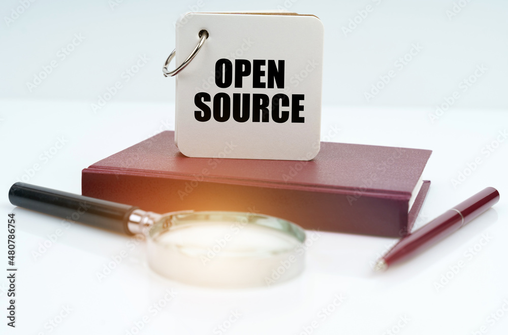 Poster On a white surface lies a red notebook, a pen, a magnifying glass and a notebook with the inscription - Open Source