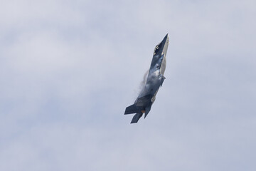 Very unusual close view of a F-35C  in a high G maneuver , with condensation clouds over the wings and afterburner on