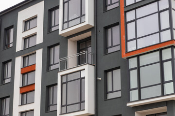 Fototapeta premium Fragment of Modern residential apartment with flat buildings exterior. Detail of New luxury house and home complex. Part of City Real estate property and condo architecture. Copy space