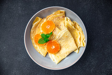 crepes citrus thin pancakes sweet dessert tangerine or tangerines breakfast healthy meal food snack on the table copy space food background rustic top view