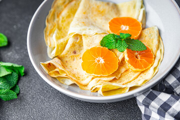 crepes citrus thin pancakes sweet dessert tangerine or tangerines breakfast healthy meal food snack on the table copy space food background rustic top view