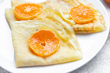 Naklejka na ściany i meble crepes citrus thin pancakes sweet dessert tangerine or tangerines breakfast healthy meal food snack on the table copy space food background rustic top view