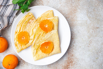 crepes citrus thin pancakes sweet dessert tangerine or tangerines breakfast healthy meal food snack on the table copy space food background rustic top view