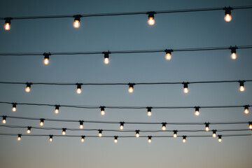 many light bulbs on the wire. lighting in the cafe. garland of lamps