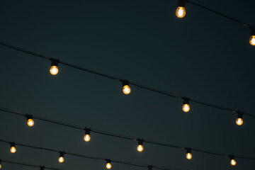 many light bulbs on the wire. lighting in the cafe. garland of lamps