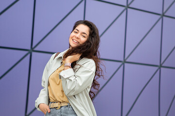 Smiling young stylish woman with curly hair