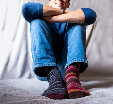 Teenager boy wearing brightly mismatched differend striped socks
