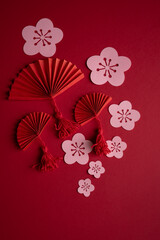 Chinese New Year. Decoration with traditional Chinese New Year motifs, cut out paper decorations on red cardboard background. Copy space. Vertical photo.