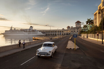 Old car on Malecon street of Havana with sunrise in background. Cuba