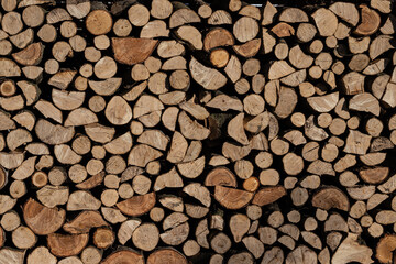 Pile of stacked triangle firewood prepared for fireplace and boiler