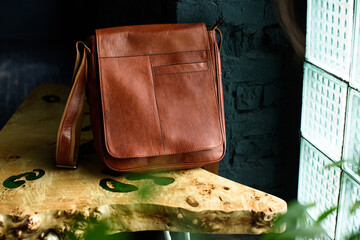 close-up photo of orange leather messanger bag on a wooden table