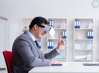 Naklejka premium Businessman with virtual reality glasses in the office