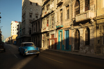 Amazing old american car on streets of Havana with colourful buildings in background. Havana, Cuba.