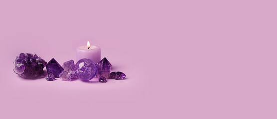 amethyst minerals set and candle on violet background. Gemstones for esoteric spiritual practice, Healing Crystal Ritual, Witchcraft, Relax Chakra. Feng Shui, reiki therapy concept. banner. copy space