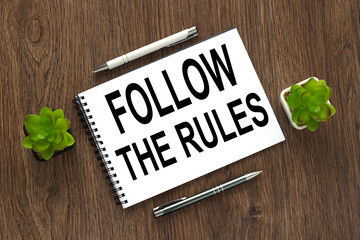 Follow The Rules text written on a notebook with pencils