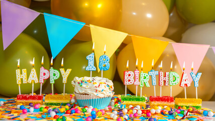 Cupcake creme with a candle for eighteen years, Greeting colorful card happy birthday 18, birthday cupcake with candles and birthday decorations.