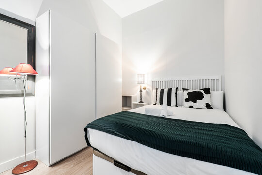 bedroom with king size bed and cow cushions with white sliding door wardrobe in short term rental apartment