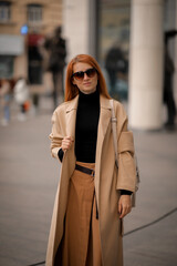 Fototapeta premium woman walking down the street. walk through the autumn city