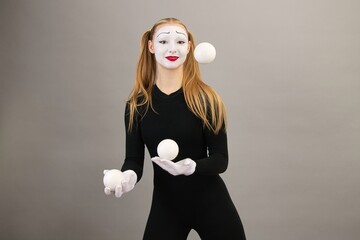 The mime artist juggles balls. Circus clown woman.