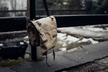 Kameratasche hängt an einem Geländer im Wald