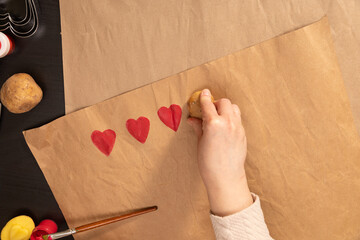 heart shaped potato stamp on craft paper. The process of decorating a gift for Valentine's Day....