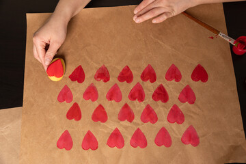 heart shaped potato stamp on craft paper. The process of decorating a gift for Valentine's Day. Getting ready for the celebration on February 14th.