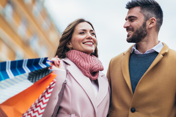 Portrait of happy couple with shopping bags after shopping in city.