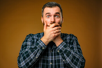 surprised man covering his mouth with both hands