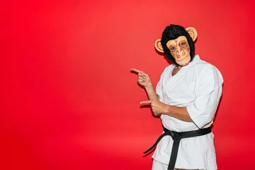 Fotobehang Man with monkey mask practicing martial arts. © karrastock
