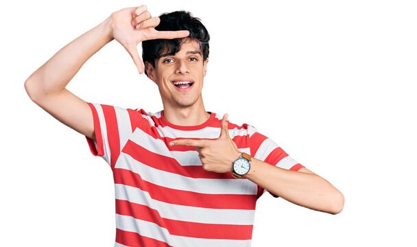 Handsome hipster young man wearing casual striped t shirt smiling making frame with hands and fingers with happy face. creativity and photography concept.