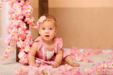 Fototapeta premium baby girl with pink flowers in pink clothes