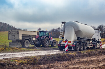 Binding agent spreader in trailer and cement tank truck on site