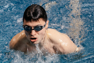 Professional swimmer competes in an indoor swimming pool race. Concept of competitions and...