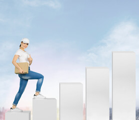 Young happy smiling brunette caucasian courier girl at the start of a career climbs the career ladder first job, career start post office worker, way to success on the background of the blue sky