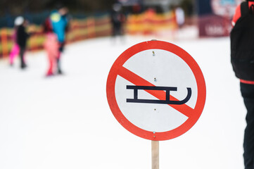 sleds forbidden sign next to a ski slope