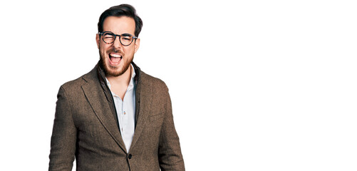 Young hispanic man wearing business jacket and glasses winking looking at the camera with sexy...