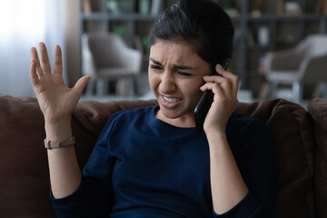 Unhappy young Indian woman holding unpleasant phone call conversation, telling complaints...