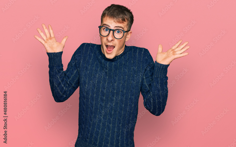 Poster Young blond man wearing casual clothes and glasses celebrating crazy and amazed for success with arms raised and open eyes screaming excited. winner concept