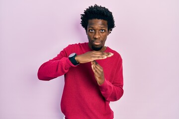 Young african american man wearing casual clothes doing time out gesture with hands, frustrated and...
