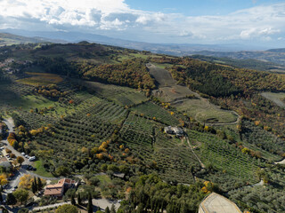 Fototapeta premium Aerial view on hills of Val d'Orcia near Castiglione d'Orcia, Tuscany, Italy. Tuscan landscape with cypress trees, vineyards, forests and ploughed fields in autumn.