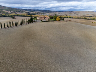 Fototapeta premium Aerial view on hills of Val d'Orcia, Tuscany, Italy. Tuscan landscape with ploughed fields in autumn.