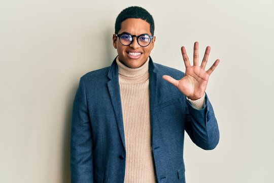 Young handsome hispanic man wearing elegant clothes and glasses showing and pointing up with fingers number five while smiling confident and happy.