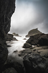 Rocky Cove with gentle waves during a storm, sandy beach