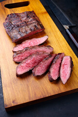 Traditional barbecue wagyu gourmet bavette steak served as close-up on a modern design wooden board