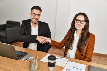 Two business workers shaking hands at the office.