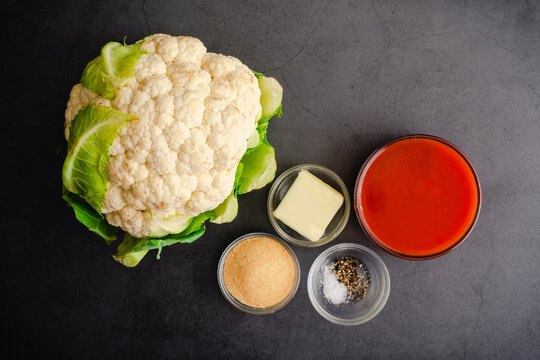 Ingredients for Buffalo Cauliflower Bites: Overhead view of a cauliflower head with other ingredients